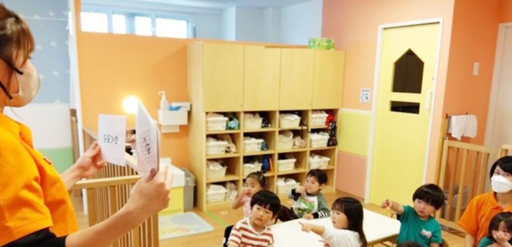 フラッシュカードを提示する保育士